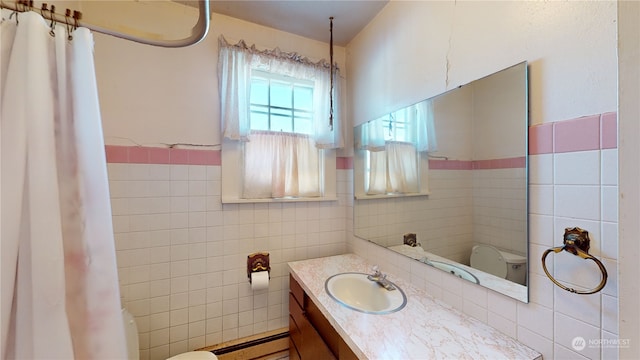 bathroom with baseboard heating, tile walls, and toilet