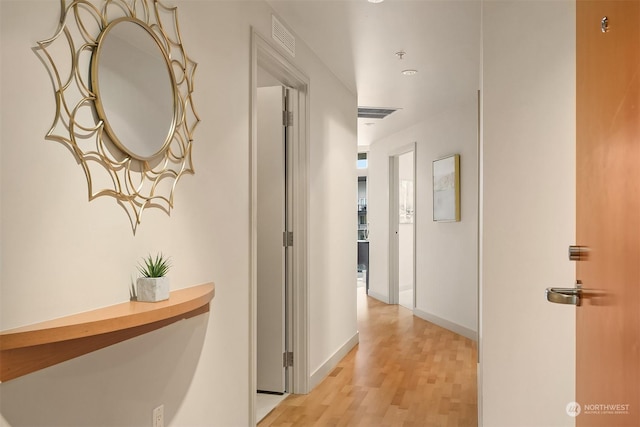 corridor with light hardwood / wood-style floors