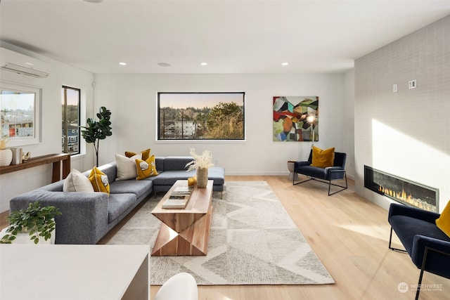 living room featuring light hardwood / wood-style floors and a wall unit AC