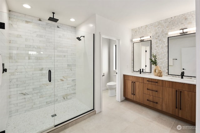 bathroom featuring vanity, toilet, and a shower with shower door