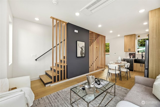 living room featuring sink and light hardwood / wood-style floors