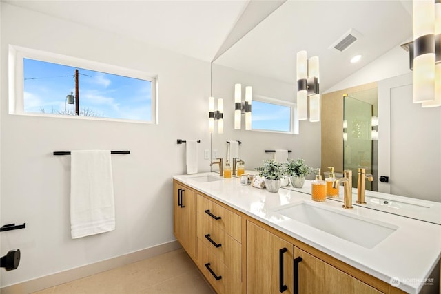 bathroom featuring vanity, a shower with shower door, and vaulted ceiling