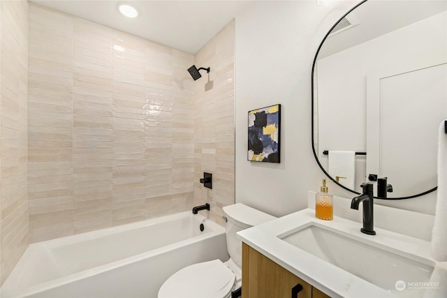 full bathroom featuring vanity, tiled shower / bath combo, and toilet