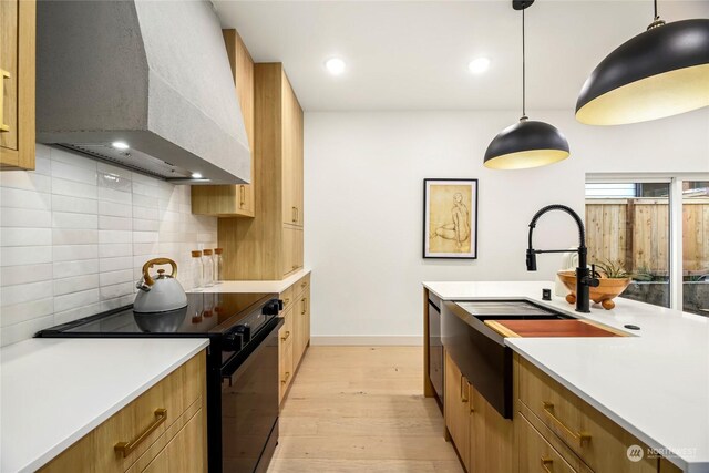 kitchen featuring pendant lighting, backsplash, custom range hood, black / electric stove, and light wood-type flooring