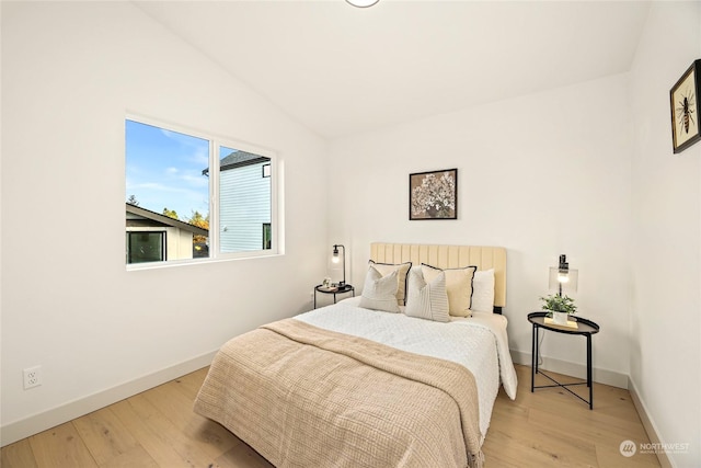 bedroom with light hardwood / wood-style floors and vaulted ceiling