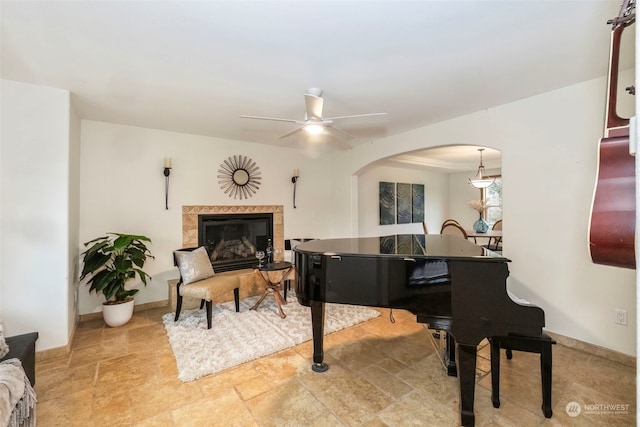 miscellaneous room featuring a tiled fireplace and ceiling fan