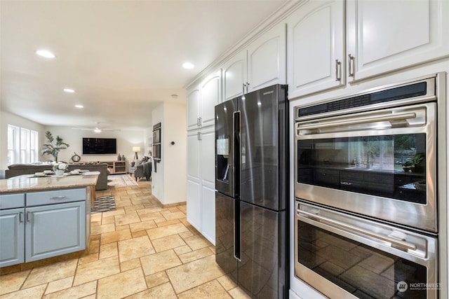 kitchen with white cabinetry, black refrigerator with ice dispenser, ceiling fan, and double oven