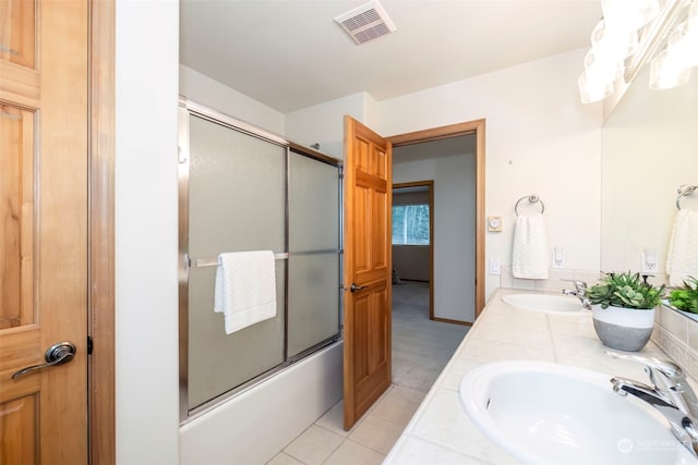 bathroom featuring tile patterned floors, vanity, and combined bath / shower with glass door