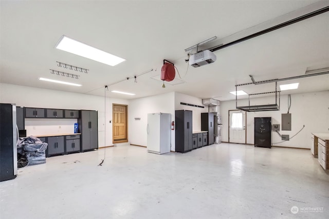 garage with white refrigerator, electric panel, and a garage door opener