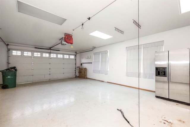 garage featuring stainless steel fridge and a garage door opener