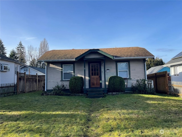 bungalow-style house featuring cooling unit and a front lawn