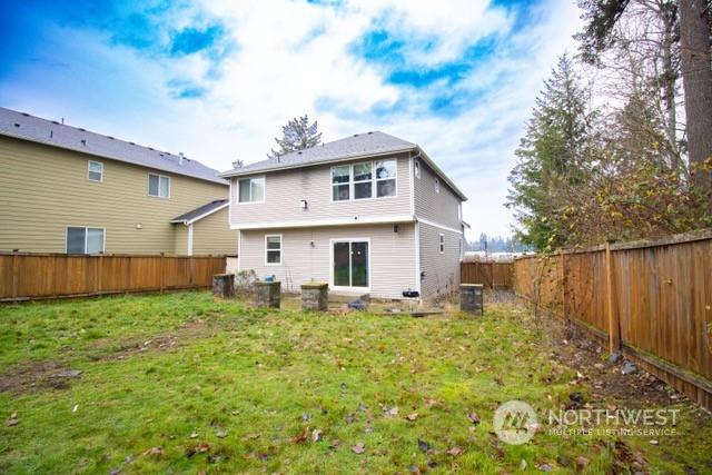 back of property with central air condition unit and a lawn