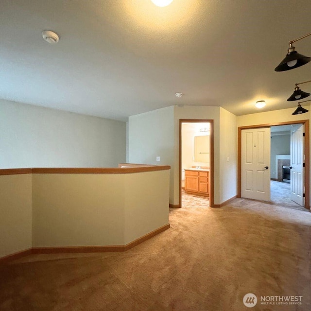 unfurnished room featuring light colored carpet and baseboards