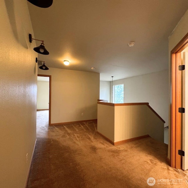 unfurnished room with baseboards and light carpet