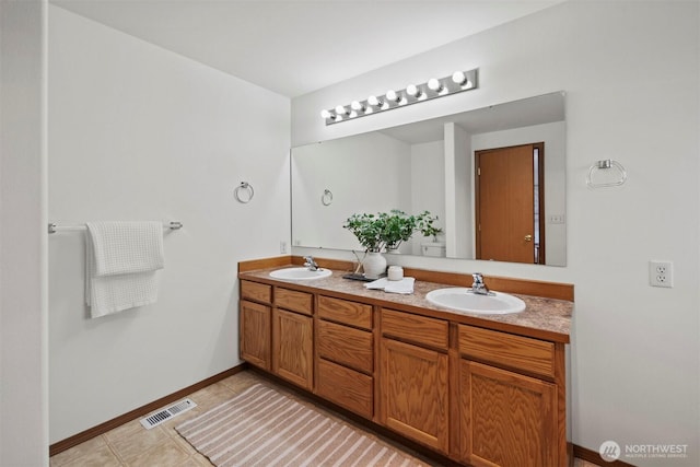 full bath featuring double vanity, a sink, visible vents, and tile patterned floors