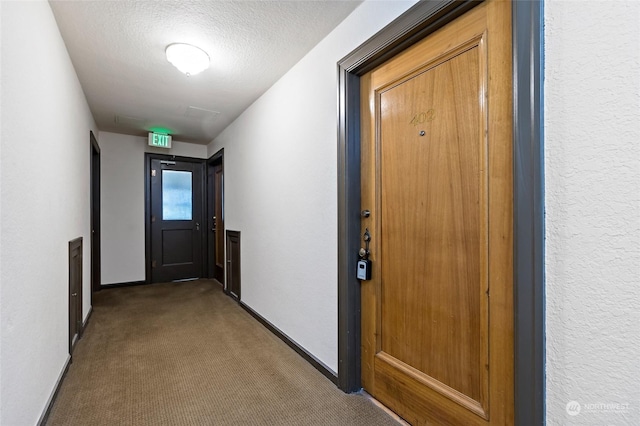 corridor featuring carpet and a textured ceiling