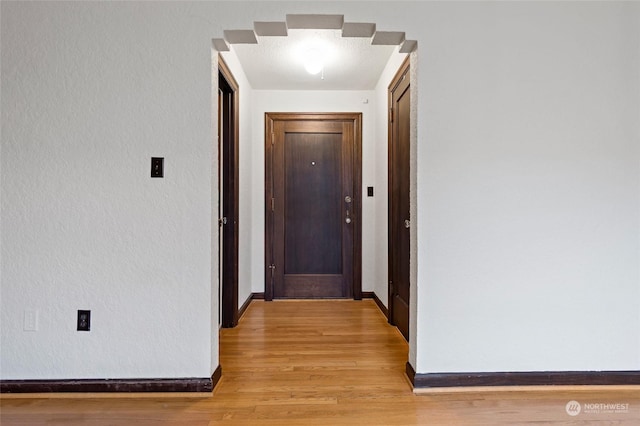 hallway with light hardwood / wood-style floors