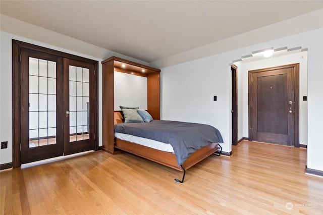 bedroom featuring access to outside, french doors, and light hardwood / wood-style floors