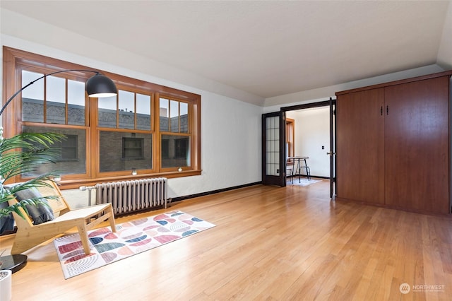 interior space featuring french doors, light wood-type flooring, and radiator