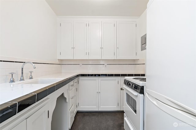 kitchen with white cabinets, backsplash, white appliances, and sink