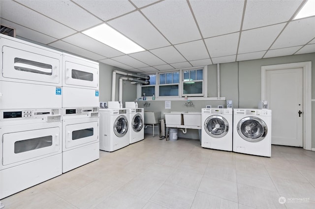 clothes washing area featuring washer and clothes dryer, sink, and stacked washer / dryer