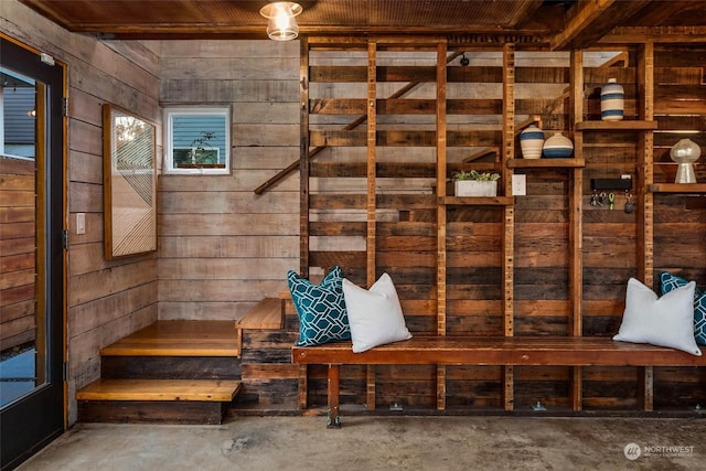 mudroom featuring concrete floors, wooden ceiling, and wooden walls