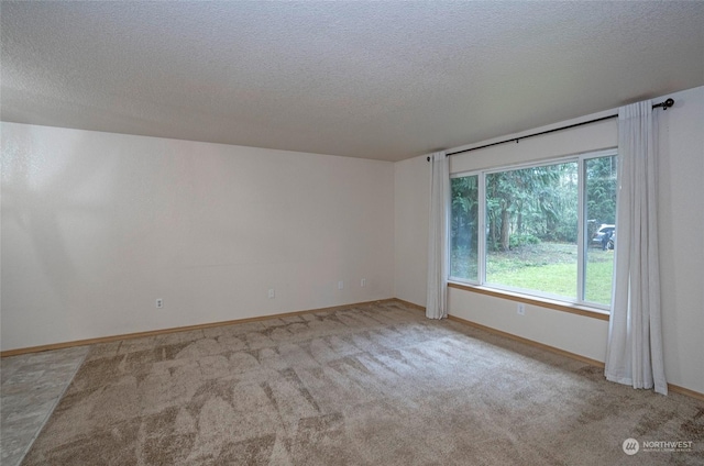 carpeted empty room featuring a textured ceiling