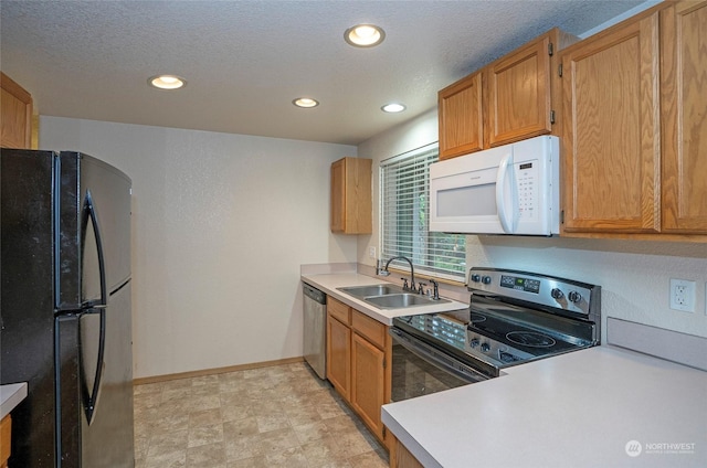 kitchen with sink, stainless steel appliances, and a textured ceiling