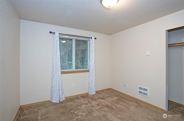 unfurnished bedroom with carpet, a textured ceiling, and a closet