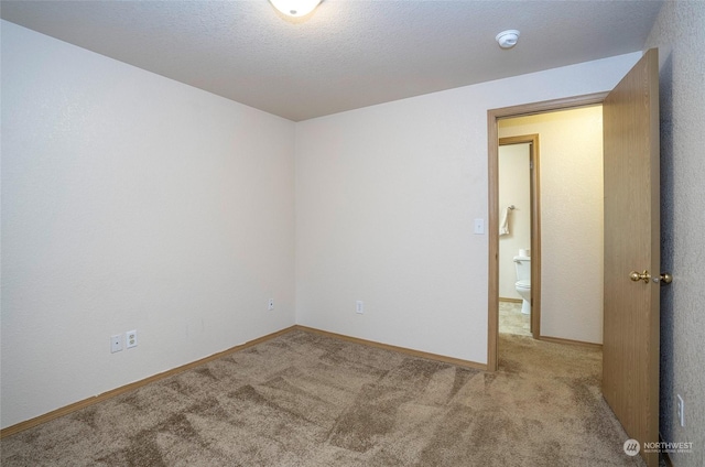 carpeted spare room with a textured ceiling