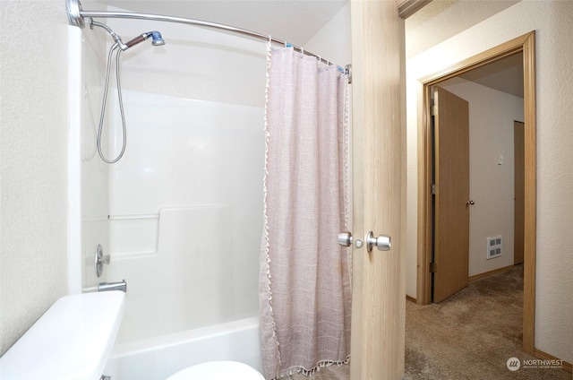 bathroom featuring shower / tub combo and toilet