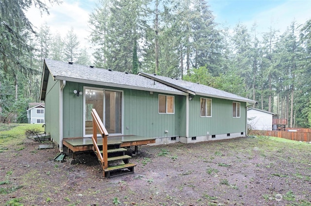 rear view of property featuring a wooden deck