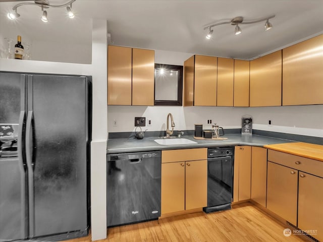 kitchen with sink, black appliances, and light hardwood / wood-style floors