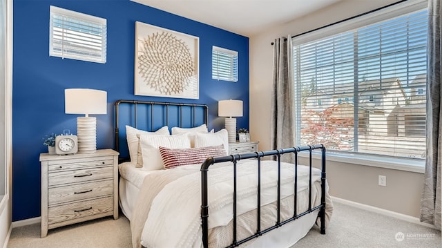 bedroom with light colored carpet and multiple windows