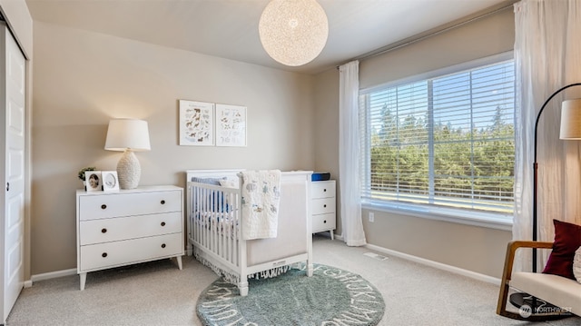 bedroom with light carpet and a nursery area