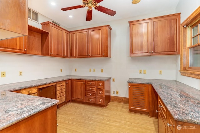 kitchen with light stone countertops, light hardwood / wood-style flooring, and ceiling fan