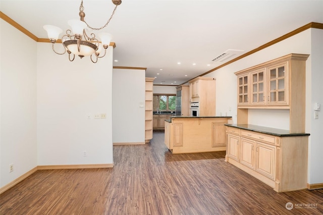 kitchen with dark wood-type flooring, oven, a chandelier, light brown cabinetry, and ornamental molding