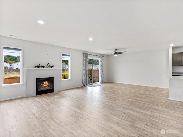 unfurnished living room featuring ceiling fan and light hardwood / wood-style flooring