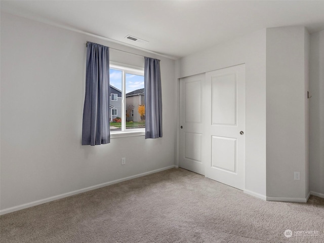 unfurnished bedroom featuring carpet and a closet