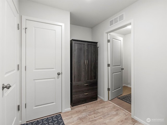 corridor with light hardwood / wood-style floors