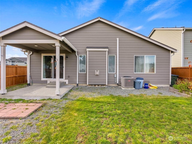 rear view of house with a lawn, central air condition unit, and a patio