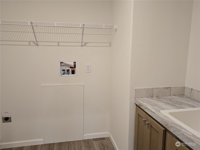 laundry area featuring hardwood / wood-style floors, cabinets, sink, washer hookup, and hookup for an electric dryer