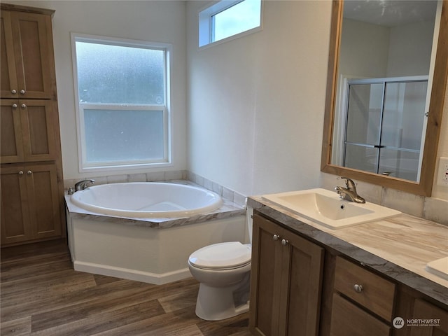 full bathroom with vanity, toilet, plus walk in shower, and hardwood / wood-style flooring