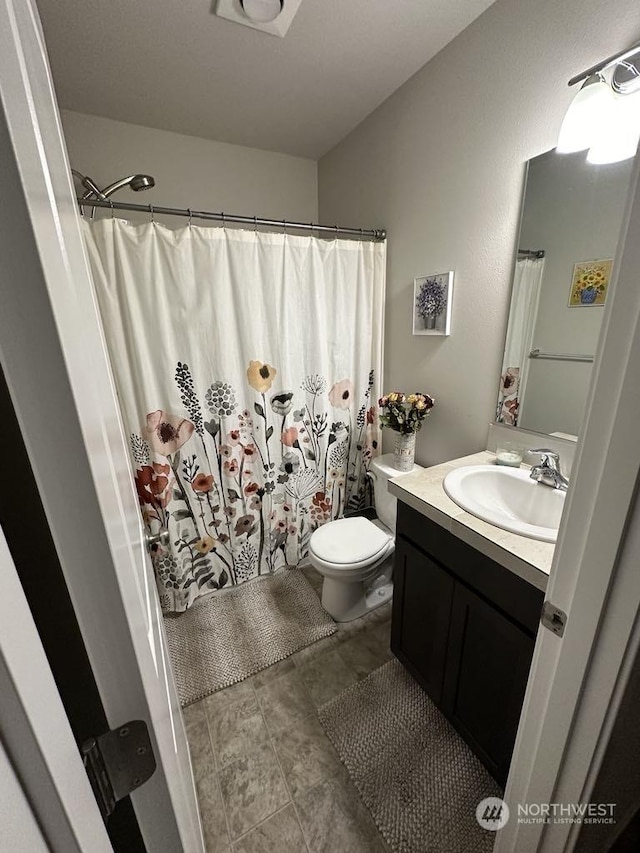 bathroom featuring vanity, curtained shower, and toilet