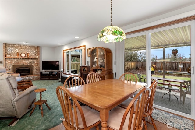 dining room featuring a brick fireplace and recessed lighting