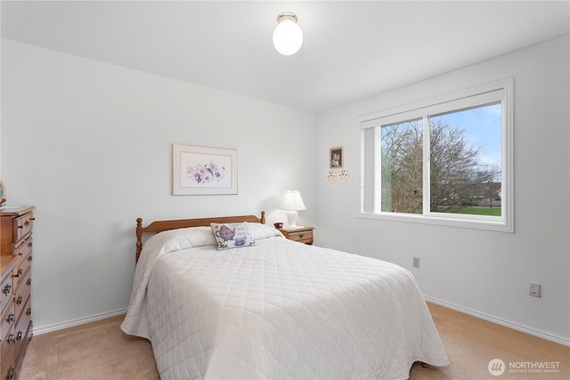 bedroom with baseboards and light carpet