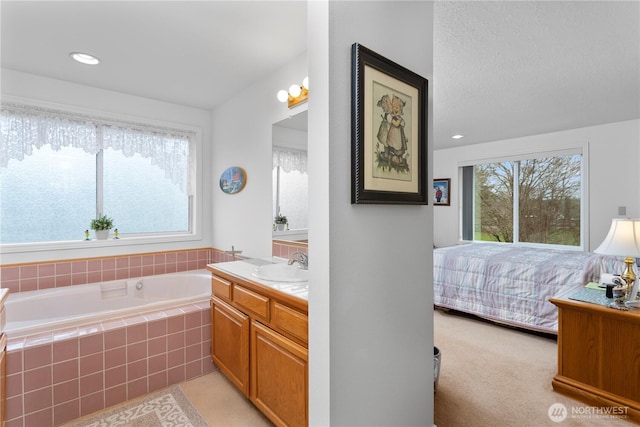 ensuite bathroom featuring vanity, recessed lighting, connected bathroom, and a bath