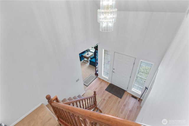 foyer featuring a high ceiling, wood finished floors, and a notable chandelier