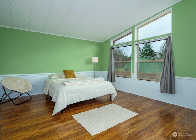 bedroom with dark hardwood / wood-style flooring, vaulted ceiling, and ornamental molding