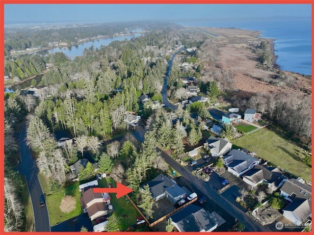 drone / aerial view featuring a forest view and a water view